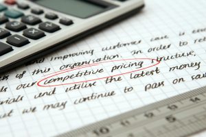 competitive pricing handwritten text encircled on paper